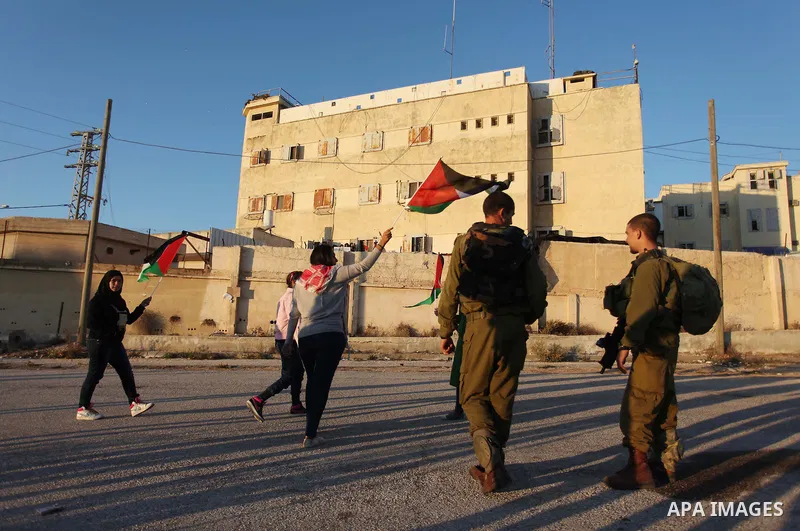 Palestinian feminine activists break inside a military camp near the West Bank city of Ramallah on Nov. 15, 2012. About 20 Palestinian activists Break in Biet Eil militarily camp rising Flags and banners supporting Gaza...