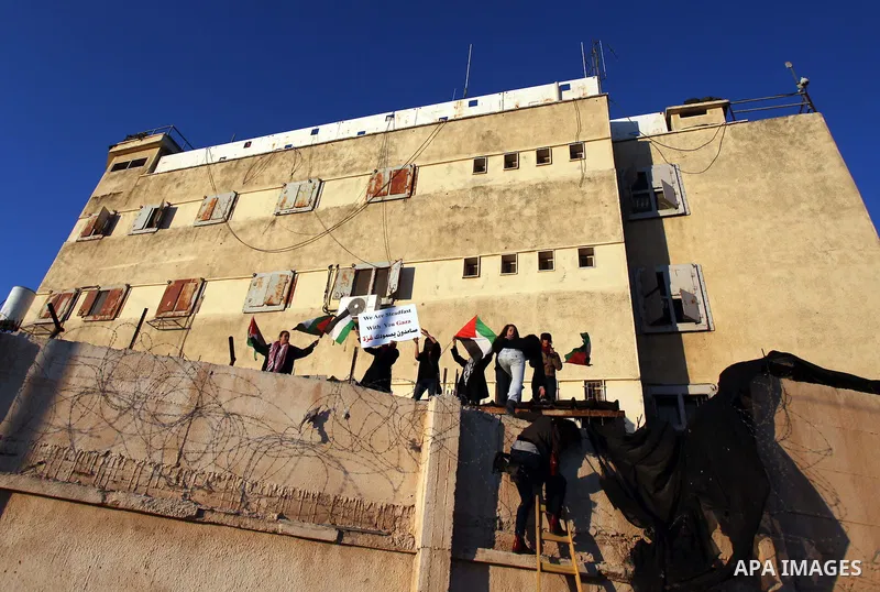 Palestinian feminine activists break inside a military camp near the West Bank city of Ramallah on Nov. 15, 2012. About 20 Palestinian activists Break in Biet Eil militarily camp rising Flags and banners supporting Gaza...