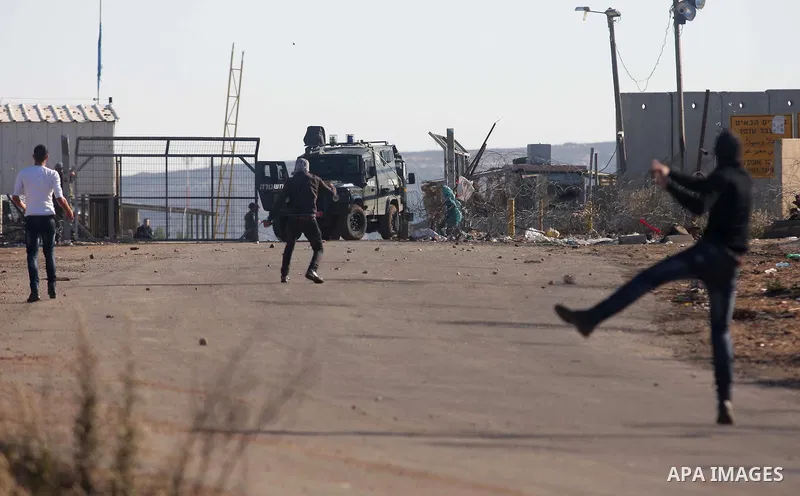 Palestinian protesters throw stones at Israeli troops during clashes against Israel's operations in Gaza Strip, outside Ofer, an Israeli military prison near the West Bank city of Ramallah, Thursday, Nov. 15, 2012. Meanw...