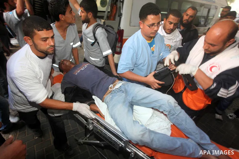Palestinian rescue teams carry a wounded man following an Israeli air strike on Gaza city on November 15, 2012. Israeli air strikes have killed more than ten Gazans, including top Hamas commander Ahmed Jaabari, as three...