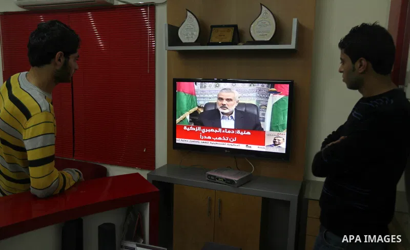 Palestinians watch TV during a speech of Palestinian Prime Minister in Gaza strip Ismail Haniyeh on Al Aqsa television Thursday, Nov. 15, 2012. Haniyeh eulogized Hamas military chief Ahmed Jabari, who was killed Wednesda...