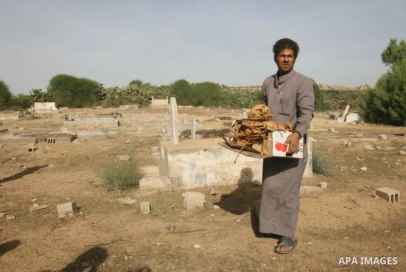 A Palestinian man carries bones from a grave after an Israeli airstrike on a cemetery in the southern of Gaza strip town of Rafah on November 16, 2012. Missiles continue to be fired on Israeli targets by Palestinian mili...