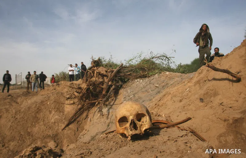 A Palestinian man carries bones from a grave after an Israeli airstrike on a cemetery in the southern of Gaza strip town of Rafah on November 16, 2012. Missiles continue to be fired on Israeli targets by Palestinian mili...