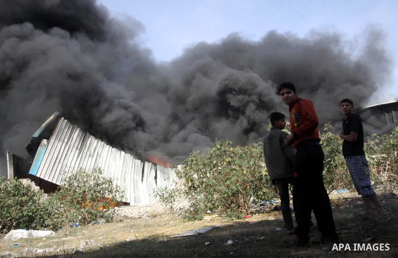 Palestinians stand near a factory which according to Palestinians was hit by an Israeli air strike in Gaza November 16, 2012. Egyptian Prime Minister Hisham Kandil arrived in the Gaza Strip on Friday to show solidarity w...