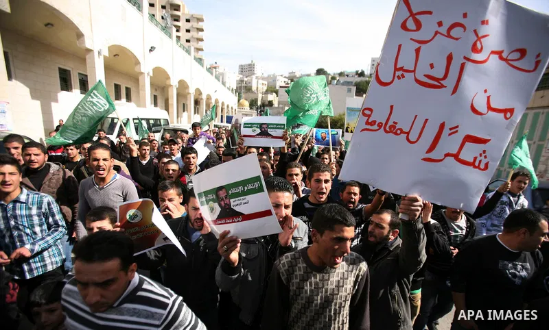 Palestinian Hamas supporters wave flags during a protest against Israel's operations in Gaza Strip, in the West Bank city of Hebron 16 November 2012. Reports state that missiles continue to be fired on Israeli targets by...