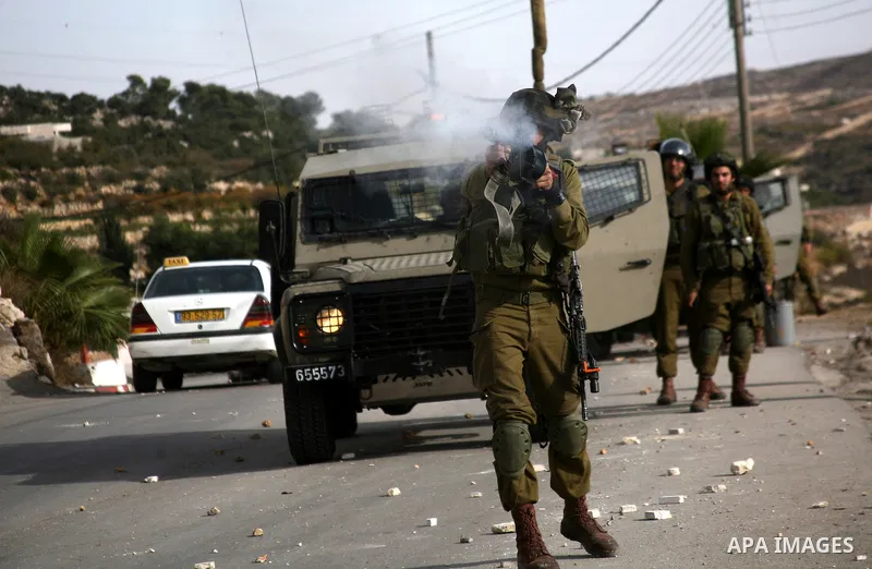 Israel soldiers fire tear gas at Palestinian demonstrators during clashes following a protest against Israel's operations in Gaza Strip in the village of Beit Ummar near the West Bank city of Hebron on November, 16, 2012...