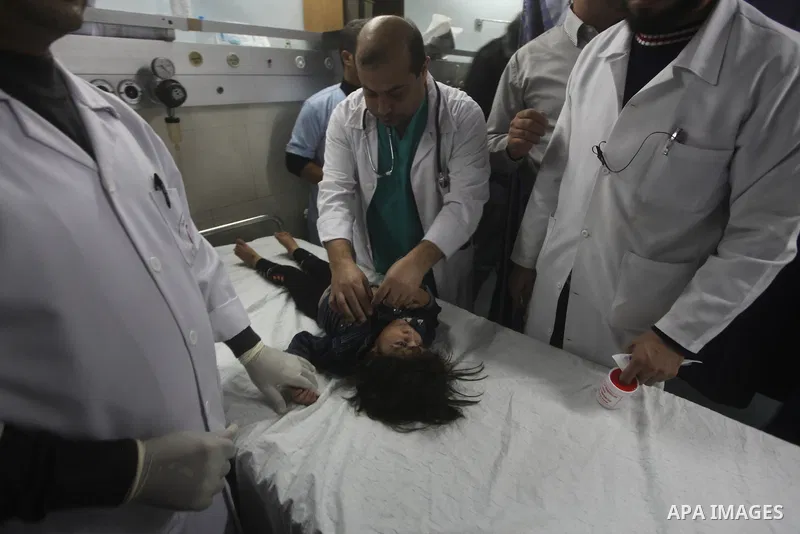 A Palestinian man carries an injured child into the treatment room of Shifa hospital following an Israeli airstrike, in Gaza City, Friday, Nov. 16, 2012. Fierce clashes between Israeli forces and Gaza militants are conti...