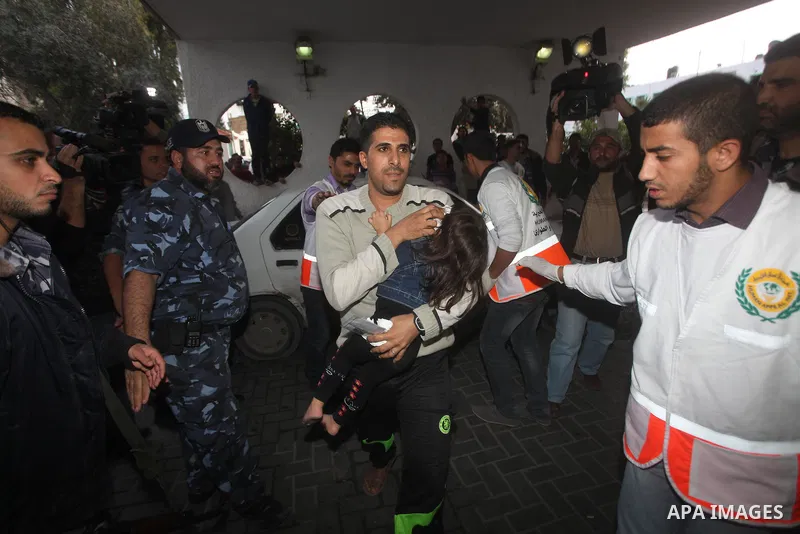 A Palestinian man carries an injured child into the treatment room of Shifa hospital following an Israeli airstrike, in Gaza City, Friday, Nov. 16, 2012. Fierce clashes between Israeli forces and Gaza militants are conti...