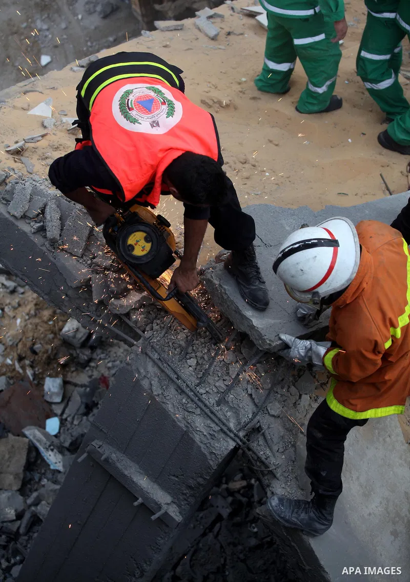 Palestinian firefighters work at the scene of an Israeli air strike on a building in the Jebaliya refugee camp in the northern Gaza Strip, Saturday, Nov. 17, 2012. Israel bombarded the Hamas-ruled Gaza Strip with more th...