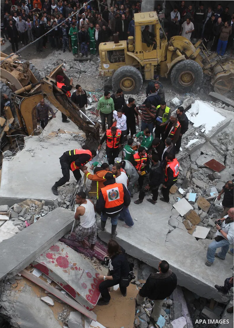 Palestinian firefighters work at the scene of an Israeli air strike on a building in the Jebaliya refugee camp in the northern Gaza Strip, Saturday, Nov. 17, 2012. Israel bombarded the Hamas-ruled Gaza Strip with more th...