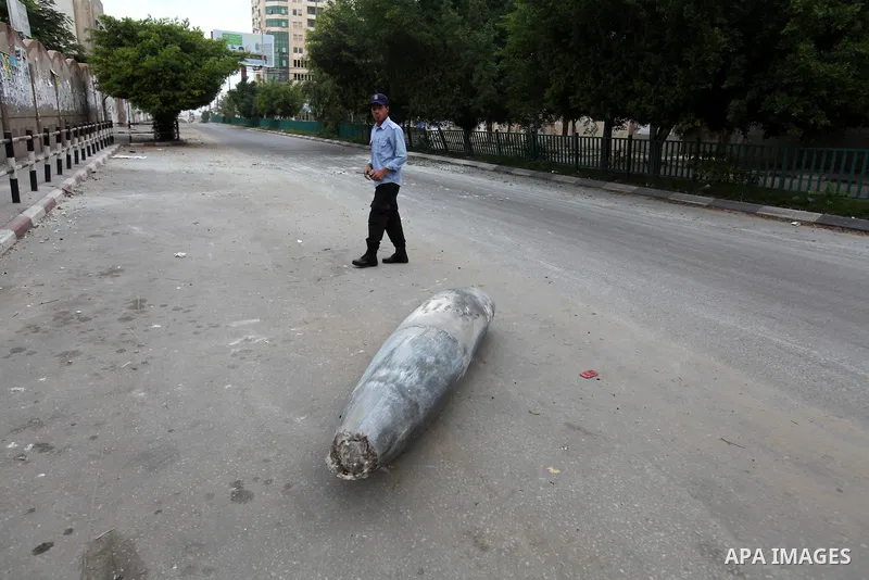 A Hamas policeman stands near an unexploded missile fired by an Israeli aircraft in Gaza City November 17, 2012. Israeli aircraft pounded Hamas government buildings in Gaza on Saturday, including the building housing the...