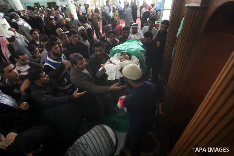 Palestinians surround the bodies of a Hamas militant, who was killed in an Israeli air strike, during his funeral at a mosque in the central Gaza Strip November 17, 2012. Israeli aircraft bombed Hamas government building...