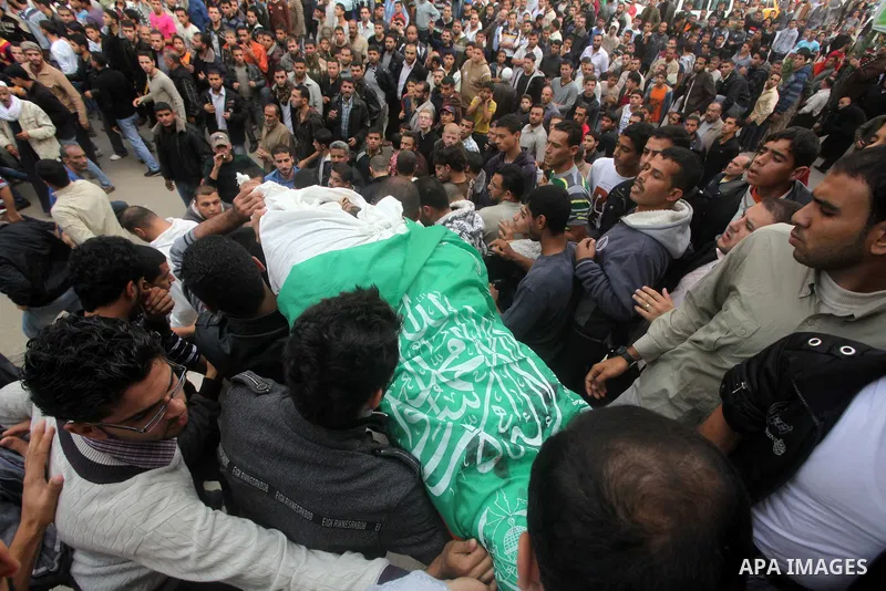 Palestinian mourners carry the bodies of a man during the funeral of people killed in Israeli air strikes in Maghazi refugee camp in central Gaza Strip on November 17, 2012. Israeli strikes on Gaza killed at least eight...
