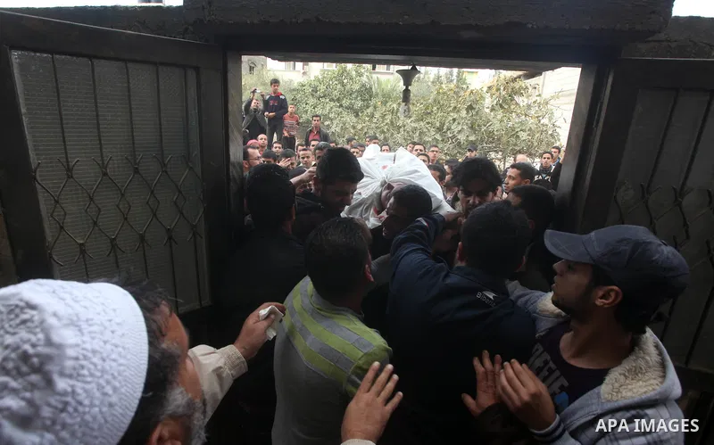 Palestinian mourners carry the body of a man during the funeral of people killed in Israeli air strikes in Maghazi refugee camp in central Gaza Strip on November 17, 2012. Israeli strikes on Gaza killed at least eight Pa...