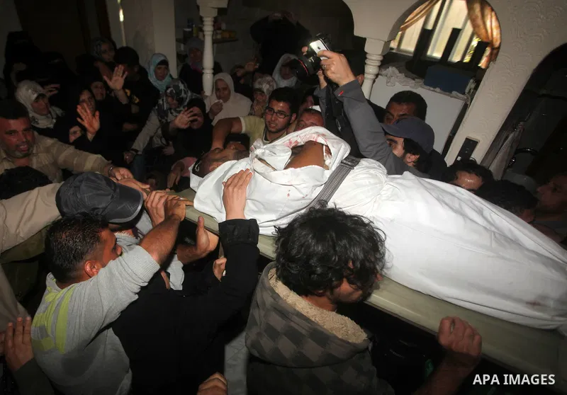 Palestinian mourners carry the body of a man during the funeral of people killed in Israeli air strikes in Maghazi refugee camp in central Gaza Strip on November 17, 2012. Israeli strikes on Gaza killed at least eight Pa...