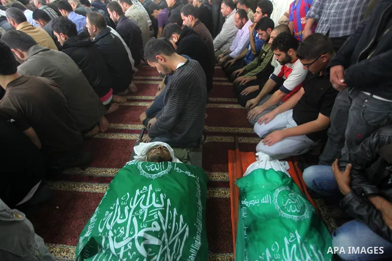 Palestinians surround the bodies of a Hamas militant, who was killed in an Israeli air strike, during his funeral at a mosque in the central Gaza Strip November 17, 2012. Israeli aircraft bombed Hamas government building...