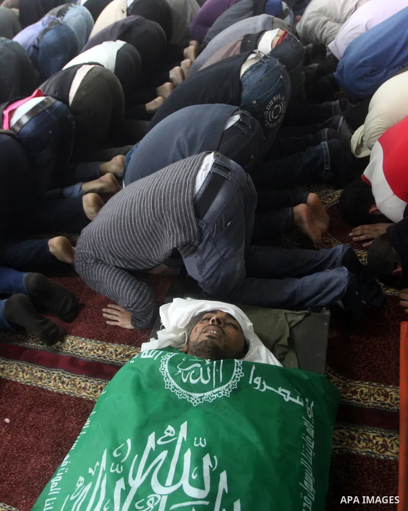 Palestinians surround the bodies of a Hamas militant, who was killed in an Israeli air strike, during his funeral at a mosque in the central Gaza Strip November 17, 2012. Israeli aircraft bombed Hamas government building...