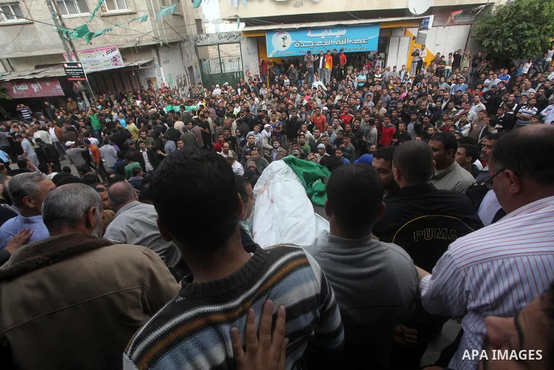 Palestinian mourners carry the bodies of a man during the funeral of people killed in Israeli air strikes in Maghazi refugee camp in central Gaza Strip on November 17, 2012. Israeli strikes on Gaza killed at least eight...