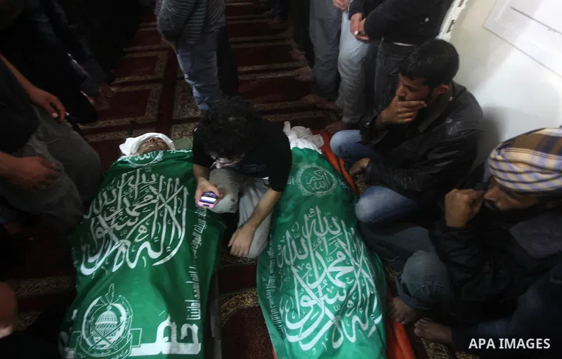 Palestinians surround the bodies of a Hamas militant, who was killed in an Israeli air strike, during his funeral at a mosque in the central Gaza Strip November 17, 2012. Israeli aircraft bombed Hamas government building...