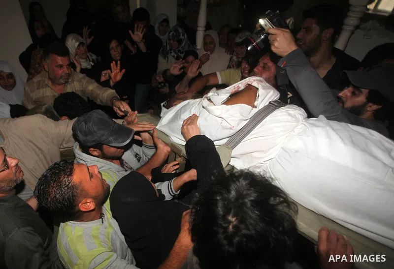 Palestinian mourners carry the body of a man during the funeral of people killed in Israeli air strikes in Maghazi refugee camp in central Gaza Strip on November 17, 2012. Israeli strikes on Gaza killed at least eight Pa...