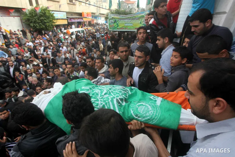 Palestinian mourners carry the bodies of a man during the funeral of people killed in Israeli air strikes in Maghazi refugee camp in central Gaza Strip on November 17, 2012. Israeli strikes on Gaza killed at least eight...