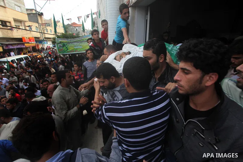 Palestinian mourners carry the bodies of a man during the funeral of people killed in Israeli air strikes in Maghazi refugee camp in central Gaza Strip on November 17, 2012. Israeli strikes on Gaza killed at least eight...