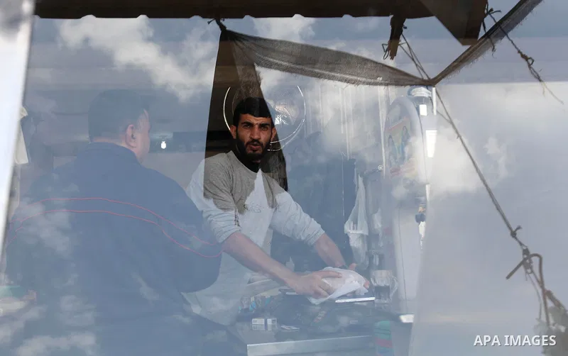 A Palestinian man stands in a butcher shop at a market, while Israeli aircraft continue the military operation on Gaza strip, in central Gaza city on November 17, 2012. Israeli aircraft bombed Hamas government buildings...