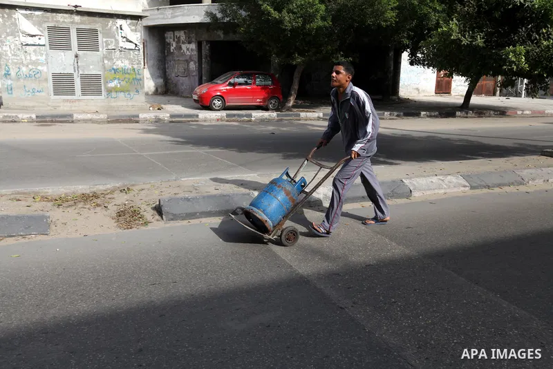 A Palestinian man pushes a gas canister at the street, while Israeli aircraft continue the military operation on Gaza strip, in central Gaza city on November 17, 2012. Israeli aircraft bombed Hamas government buildings i...