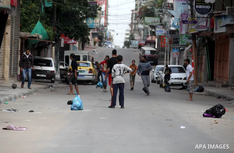 Palestinian youths play football at a street while Israeli aircraft continue the military operation on Gaza strip, in central Gaza city on November 17, 2012. Israeli aircraft bombed Hamas government buildings in Gaza on...