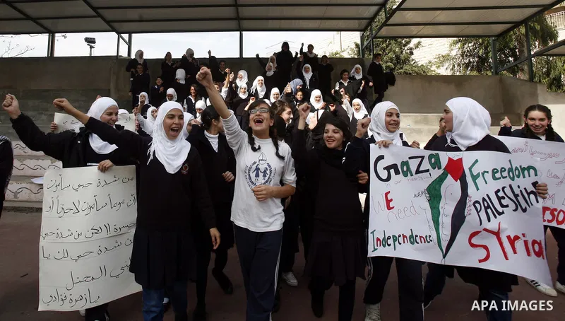 Palestinian students shout slogans during a protest against Israel's military operation in the Gaza Strip, in Jerusalem, on November 17, 2012. Reports state that Israel has put 75,000 reservists on standby amid speculati...