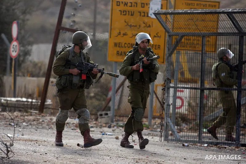 An Israeli border policeman fires a tear gas canister during clashes with Palestinian stone-throwers outside Ofer prison near the West Bank city of Ramallah November 17, 2012. The clashes broke out following a protest ag...