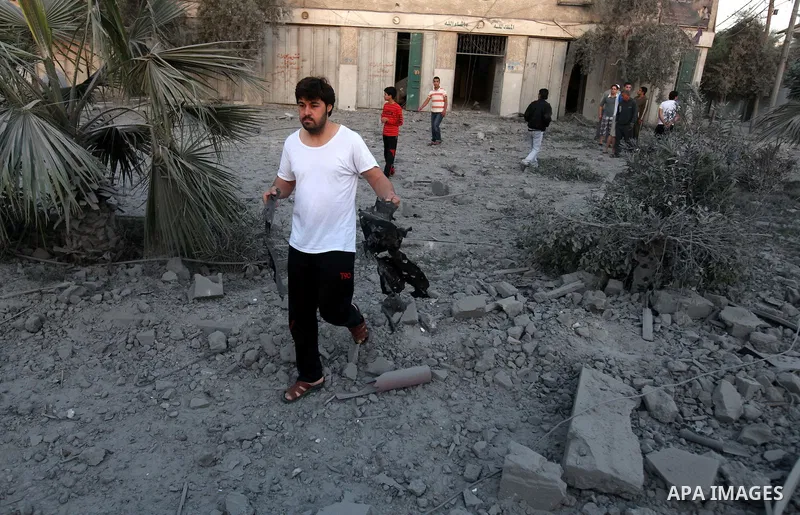 A Palestinian man inspects the damage after an Israeli airstrike in the central of Gaza city, November 18, 2012. Israeli war planes hit a Gaza City media centre and homes in northern Gaza in the early morning, as the dea...