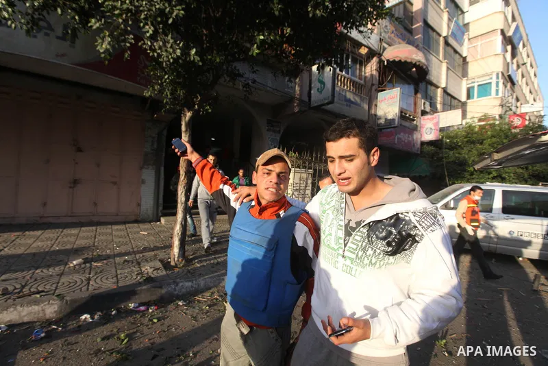 A Palestinian journalist gestures and walks next a Hamas television channel Al-Aqsa which targeted by Israeli air strikes in Gaza City on November 18, 2012. An Israeli air strike hit a Gaza City media building on Novembe...