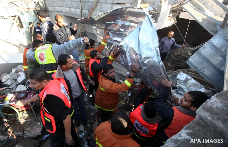 Palestinian civil defense staff use equipment to cut through metal as they search for victims stuck under the rubble of a destroyed house after it was damaged during an Israeli air strike on Gaza City on November 18, 201...