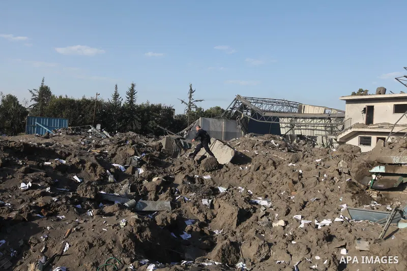 A Palestinian man inspects the damage on a rubble of a destroyed house after it was damaged during an Israeli air strike on Gaza City on November 18, 2012. Fresh Israeli air strikes hit a Gaza City media centre and homes...