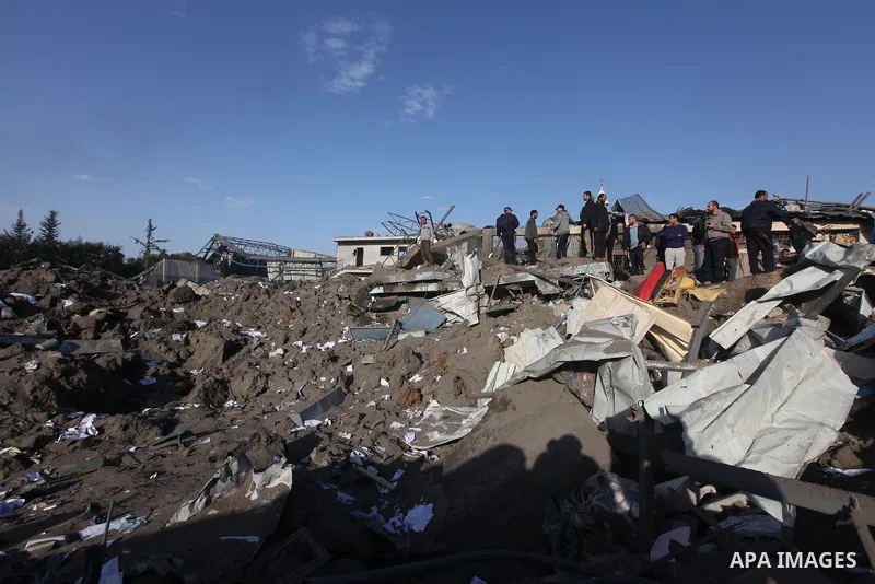Palestinians inspect the damage on a rubble of a destroyed house after it was damaged during an Israeli air strike on Gaza City on November 18, 2012. Fresh Israeli air strikes hit a Gaza City media centre and homes in no...