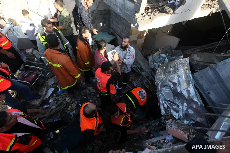 Palestinian civil defense staff use equipment to cut through metal as they search for victims stuck under the rubble of a destroyed house after it was damaged during an Israeli air strike on Gaza City on November 18, 201...