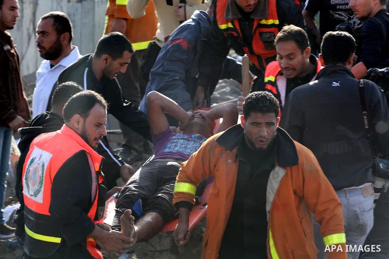 Palestinian civil defence staff carry a survivor on a stretcher after he was pulled out from under the rubble of a destroyed house following an Israeli air strike on Gaza City on November 18, 2012. Fresh Israeli air stri...