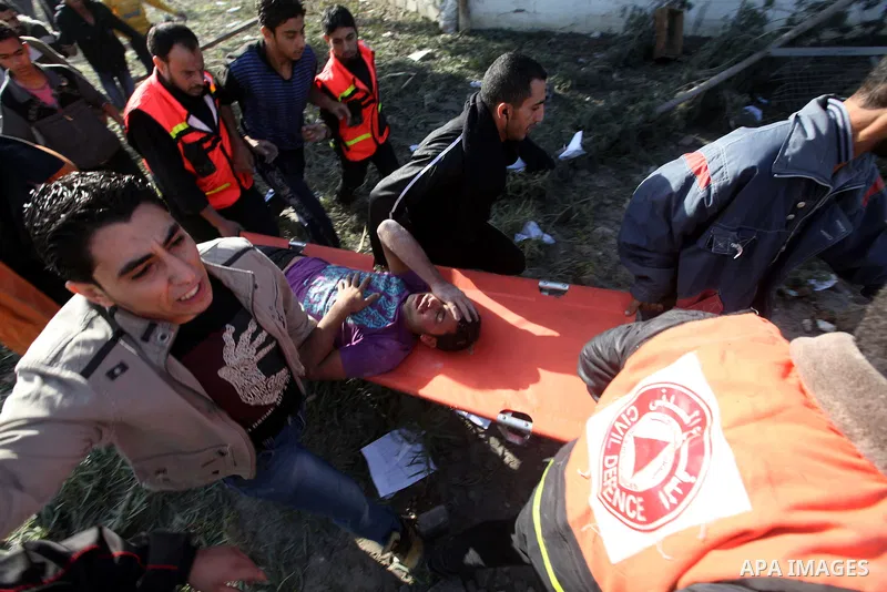Palestinian civil defence staff carry a survivor on a stretcher after he was pulled out from under the rubble of a destroyed house following an Israeli air strike on Gaza City on November 18, 2012. Fresh Israeli air stri...