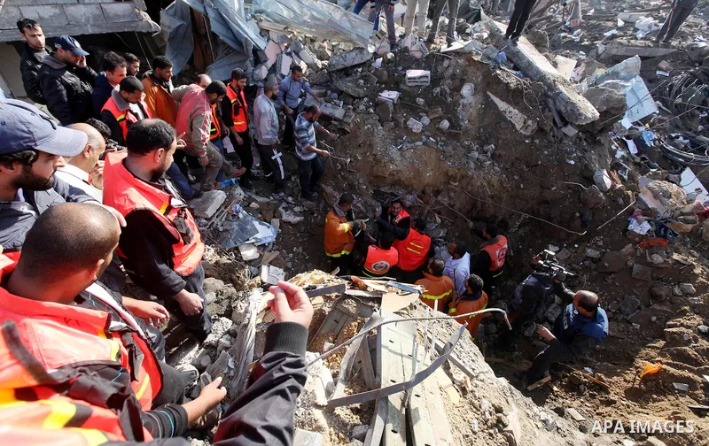 Palestinian civil defense staff use equipment to cut through metal as they search for victims stuck under the rubble of a destroyed house after it was damaged during an Israeli air strike on Gaza City on November 18, 201...