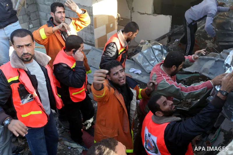 Palestinian civil defense staff use equipment to cut through metal as they search for victims stuck under the rubble of a destroyed house after it was damaged during an Israeli air strike on Gaza City on November 18, 201...