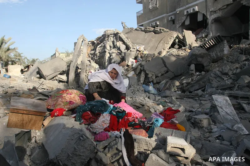 A Palestinian woman searches in the rubble of her destroyed home following Israeli air strikes on the southern Gaza Strip town of Rafah on November 18, 2012. Israeli war planes hit a Gaza City media centre and homes in n...