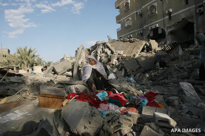 A Palestinian woman searches in the rubble of her destroyed home following Israeli air strikes on the southern Gaza Strip town of Rafah on November 18, 2012. Israeli war planes hit a Gaza City media centre and homes in n...