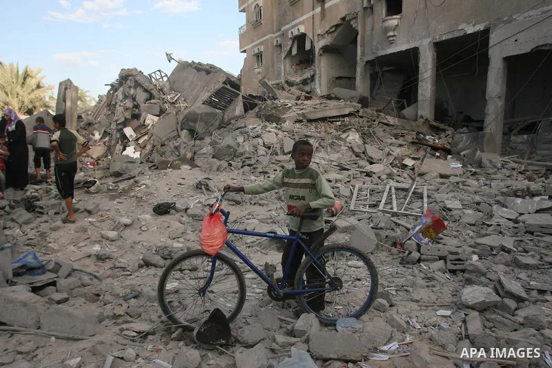 A Paelstinian boy looks at destroyed homes following Israeli air strikes on the southern Gaza Strip town of Rafah on November 18, 2012. Israeli war planes hit a Gaza City media centre and homes in northern Gaza in the ea...