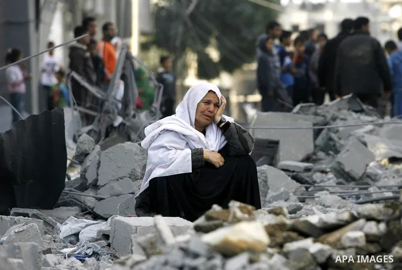 A Palestinian woman looks at her destroyed homes following Israeli air strikes on the southern Gaza Strip town of Rafah on November 18, 2012. Israeli war planes hit a Gaza City media centre and homes in northern Gaza in...