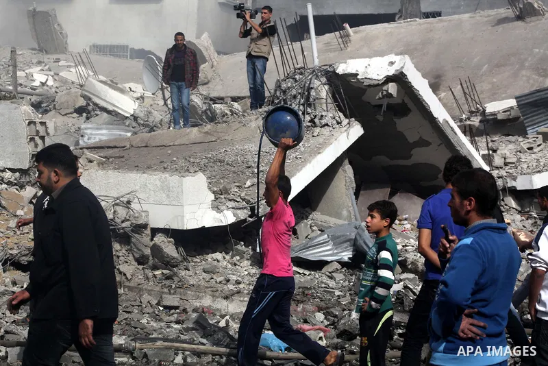 Palestinians survey the remains of a destroyed a house after Israeli air strike in al-Shijaia in the east of Gaza city on, 18 November 2012. Israel bombed militant targets in Gaza for a fifth straight day on Sunday, laun...
