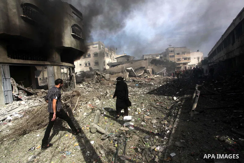 Palestinians survey the remains of a destroyed a house after Israeli air strike in al-Shijaia in the east of Gaza city on, 18 November 2012. Israel bombed militant targets in Gaza for a fifth straight day on Sunday, laun...