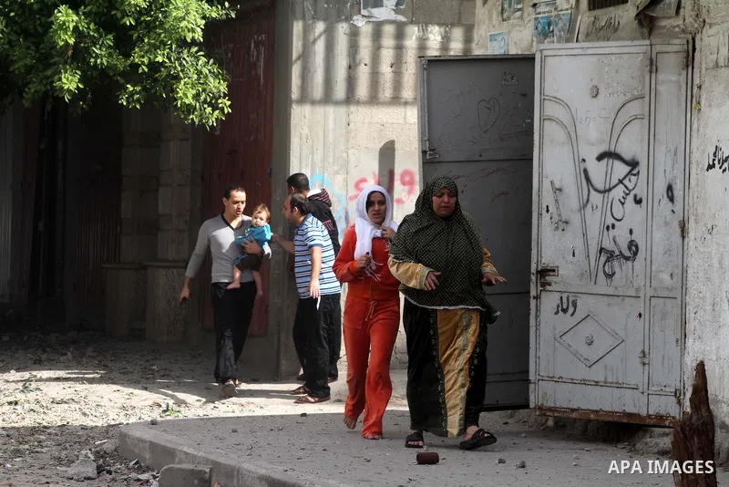 Palestinians run cover from the Israeli air strikes in al-Shijaia in the east of Gaza city on, 18 November 2012. Israel bombed militant targets in Gaza for a fifth straight day on Sunday, launching aerial and naval attac...