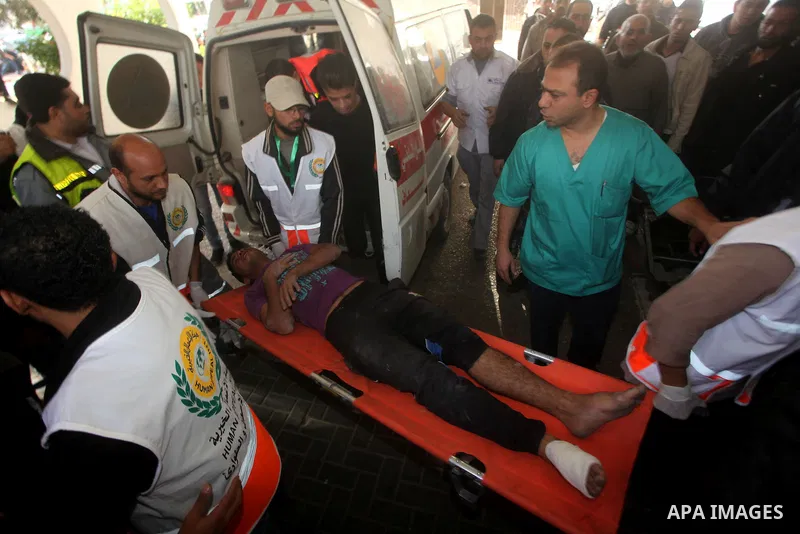Palestinian medics wheel a wounded man on a stretcher to Al-Shifa hospital in Gaza City on November 18, 2012. An Israeli air strike hit a Gaza City media building on November 18, injuring at least six journalists, as a s...