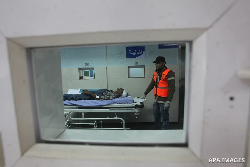 Palestinian medics wheel a wounded man on a stretcher to Al-Shifa hospital in Gaza City on November 18, 2012. An Israeli air strike hit a Gaza City media building on November 18, injuring at least six journalists, as a s...